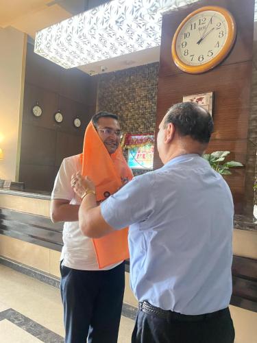 a man standing next to a man standing under a clock at The Vaishnavi in Deoghar