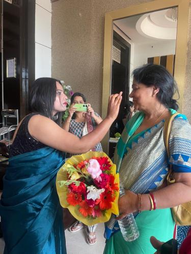 a woman taking a picture of a woman holding a bouquet at The Vaishnavi in Deoghar