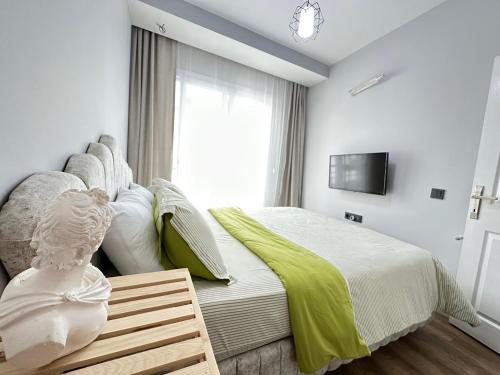 een slaapkamer met een groot bed en een televisie bij merkezde 2 odalı minimalist ev in Çiftlikköy