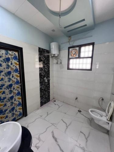 a bathroom with a toilet and a sink at Kusum Villa in Varanasi