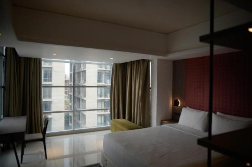 Habitación de hotel con cama y ventana grande en Lakeshore Heights en Dhaka