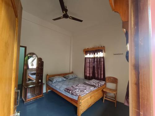 um quarto com uma cama e uma ventoinha de tecto em Niangti Guest House em Dawki