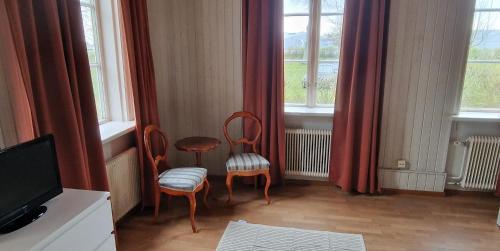 a room with two chairs and a tv and windows at Charlottsborgs Camping, Vandrarhem och Ställplats in Kristianstad