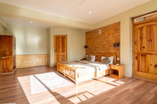 a bedroom with a bed and a wooden wall at Adu's Eternal Comfort in Leh
