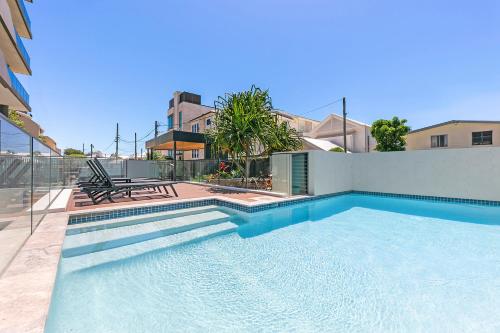a swimming pool in front of a house at 5th Floor Beachside Ocean View with Wi-Fi, Pool and Gym in Gold Coast