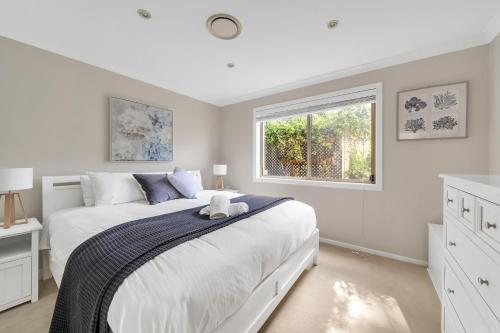 een witte slaapkamer met een groot bed en een raam bij 3-Bed with Beach Views and Entertainment Area in Surf Beach