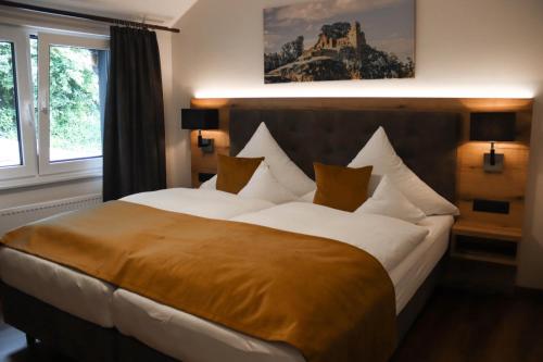 sypialnia z dużym łóżkiem z białą pościelą i poduszkami w obiekcie Hotel-Restaurant Zur Traube w mieście Altenahr