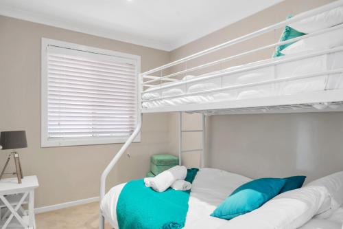 a bedroom with a bunk bed with blue pillows at 3-Bed with Beach Views and Entertainment Area in Surf Beach