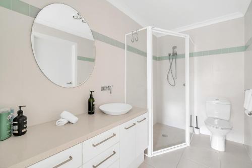 a white bathroom with a sink and a mirror at 3-Bed with Beach Views and Entertainment Area in Surf Beach