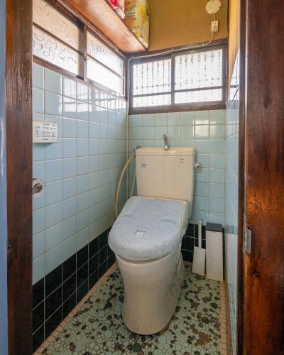 甲府市にある宝乃小宿 TAKARA no Koyadoの青いタイルの客室で、バスルーム(トイレ付)が備わります。