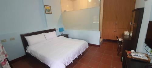 a bedroom with a white bed in a room at Jihead Villa in Xinpu