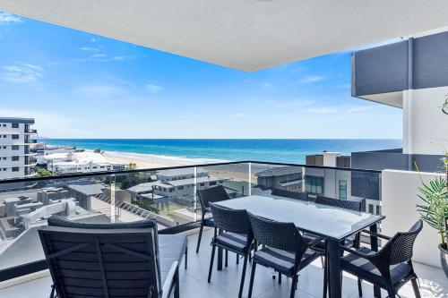 een balkon met een tafel en stoelen en de oceaan bij 5th Floor Beachside Ocean View with Wi-Fi, Pool and Gym in Gold Coast