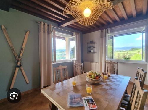 une salle à manger avec une table et une grande fenêtre dans l'établissement Le Temps des Cerises, à Saint-Georges-en-Couzan