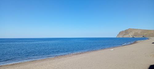 a beach with the ocean on a sunny day at Marilena in Skala Eresou