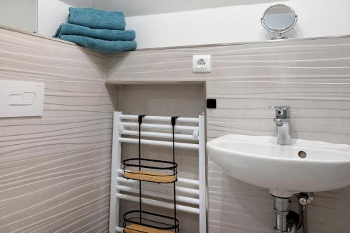 La salle de bains est pourvue d'un lavabo, d'un miroir et de serviettes. dans l'établissement Casa Caso - Apartment 5, à Achim