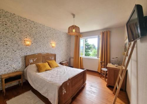 a bedroom with a bed with yellow pillows on it at Le Temps des Cerises in Saint-Georges-en-Couzan