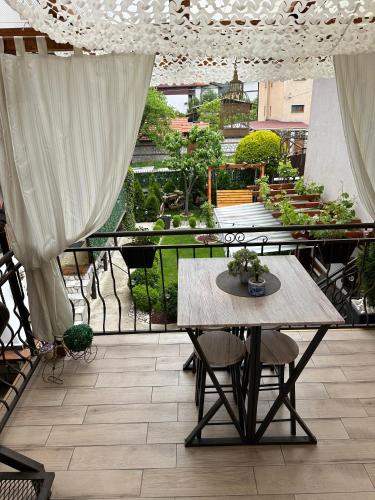 a table and chairs on a balcony with a garden at NIKI HOUSE in Bansko