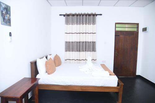 a room with a bed and a window and a table at TESHI SAFARI VILLA in Udawalawe