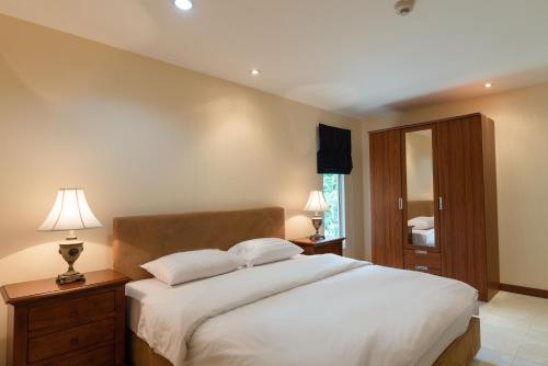 una camera da letto con un grande letto bianco con due cuscini di Jomtien Beach Residence a Jomtien Beach