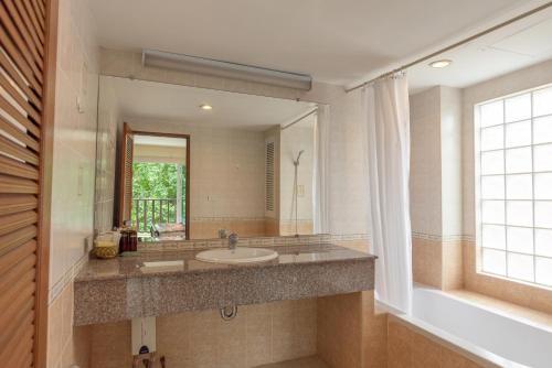 een badkamer met een wastafel en een grote spiegel bij Jomtien Beach Residence in Jomtien Beach