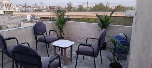 un grupo de sillas y mesas en un balcón en Frazyone hostel en Nueva Delhi