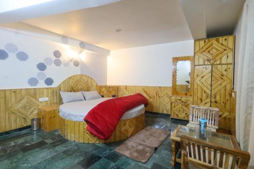 um quarto com uma cama com um cobertor vermelho em Luvya Retreats Hotel em Manali
