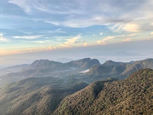 une vue sur une chaîne de montagnes sous un ciel nuageux dans l'établissement Hotel mango tree nearest Adam's peak, à Nallathanniya