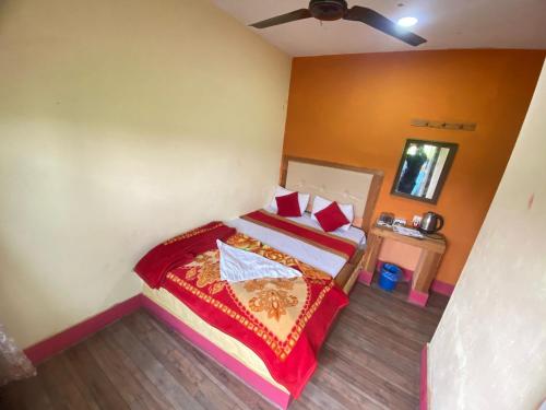 una camera con un letto con una coperta rossa di Hong Qi Hotel a Chitwan