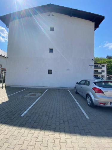 a car parked in a parking lot next to a white building at Apartament NALA in Mediaş