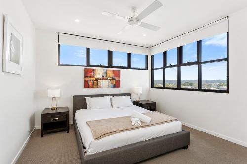 a bedroom with a large bed with windows at 5th Floor Beachside Ocean View with Wi-Fi, Pool and Gym in Gold Coast