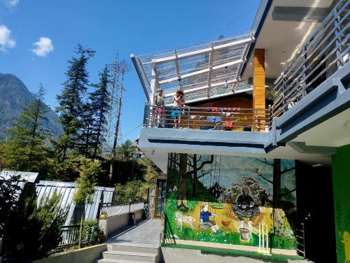 Personnes debout sur le balcon d'une maison dans l'établissement Destination Of Choj ( DOC), à Kasol