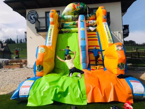 a group of people on an inflatable playground at Aparthotel Rabiań-SKI zewnętrzny basen oraz jacuzzi z podgrzewana wodą dmuchaniec i 2 place zabaw w cenie in Białka Tatrzanska