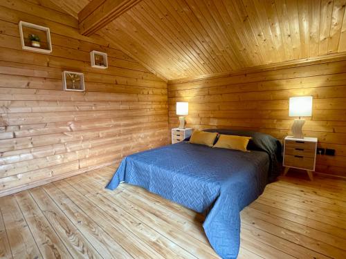 ein Schlafzimmer mit einem Bett in einer Holzhütte in der Unterkunft Chalet Pura Vida Morillon Samoëns Grand Massif 6-8 in Morillon