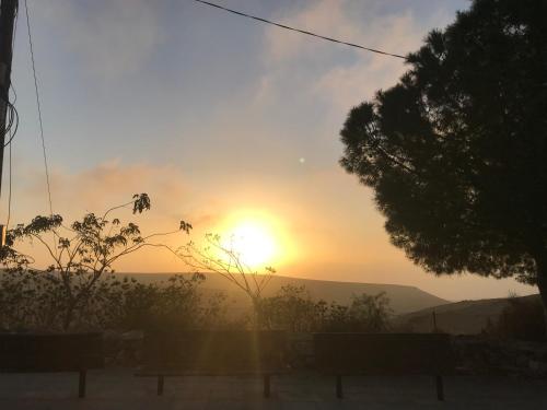 a sunset with the sun setting in the distance at סוויטות עין השמש eye sun in Arad