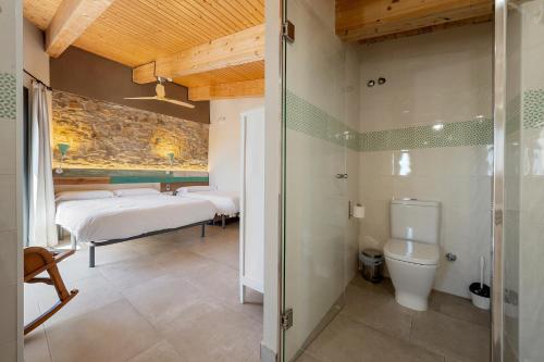 uma casa de banho com 2 camas e um chuveiro em Arassa casa rural em Rocafort de Queralt