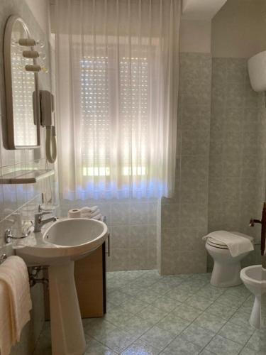 a bathroom with a sink and a toilet at Hotel Promenade in Porto SantʼElpidio