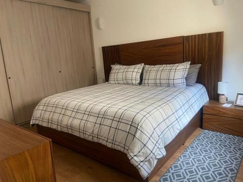 1 dormitorio con 1 cama con manta y almohadas a cuadros en VILLA CORTONA, en Santeagueda
