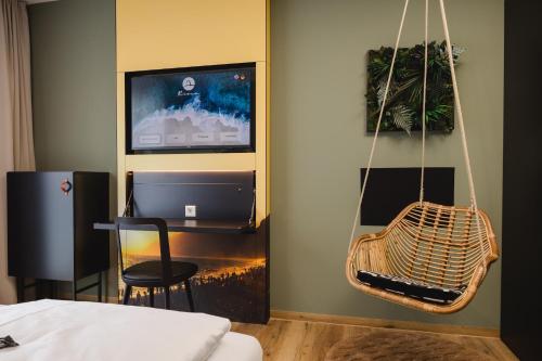 a room with a bed and a hanging chair at Rioca Stuttgart Posto 6 in Stuttgart