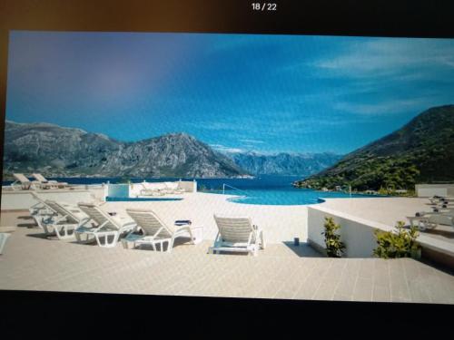 a group of lounge chairs sitting on a beach at Pool and spa apartment 1BR in Donji Morinj