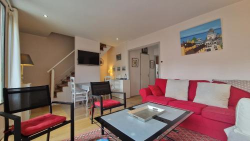 salon z czerwoną kanapą i stołem w obiekcie Grand Appartement La Source d'Evian w mieście Évian-les-Bains