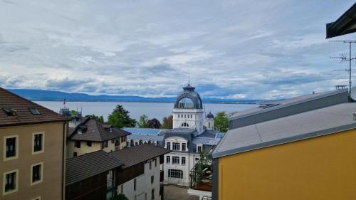 a view of a town with a building and a lake at Grand Appartement La Source d'Evian in Évian-les-Bains