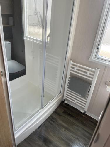 uma cabina de duche ao nível do chão com uma porta de vidro num quarto em Whitstable retreat em Seasalter