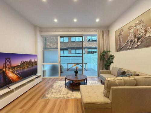 a living room with a large flat screen tv at Sydney CBD Newly Renovated Large Terrace in Sydney