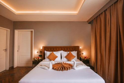 a bedroom with a large white bed with orange pillows at Hotel Polo Towers Agartala in Agartala