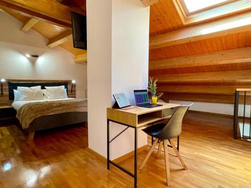 a bedroom with a bed and a desk with a laptop at Prime Loft LA RIOJA in Azarrulla
