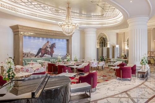 a dining room with tables and chairs and a painting at Al Habtoor Palace - Preferred Hotels & Resorts in Dubai