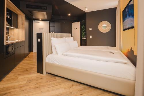 a large white bed in a small room at Rioca Stuttgart Posto 6 in Stuttgart