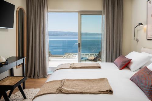 a hotel room with two beds and a large window at New! Casa GENI-heated pool, 3 bedrooms, sea views in Omiš