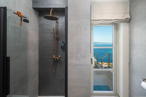 a shower with a glass door and a window at New! Casa GENI-heated pool, 3 bedrooms, sea views in Omiš