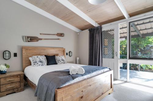 a bedroom with a bed and a large window at Secluded 3-Bed Retreat Moments to the Beach in Surf Beach